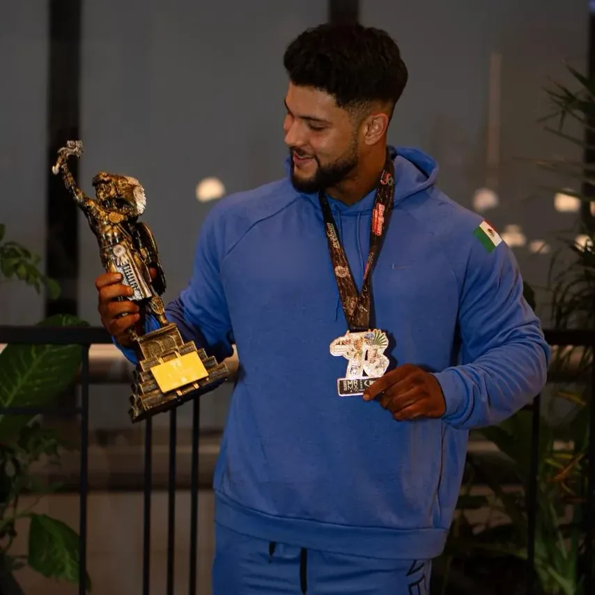 Kinetix athlete in a blue hoodie with his trophy and medal