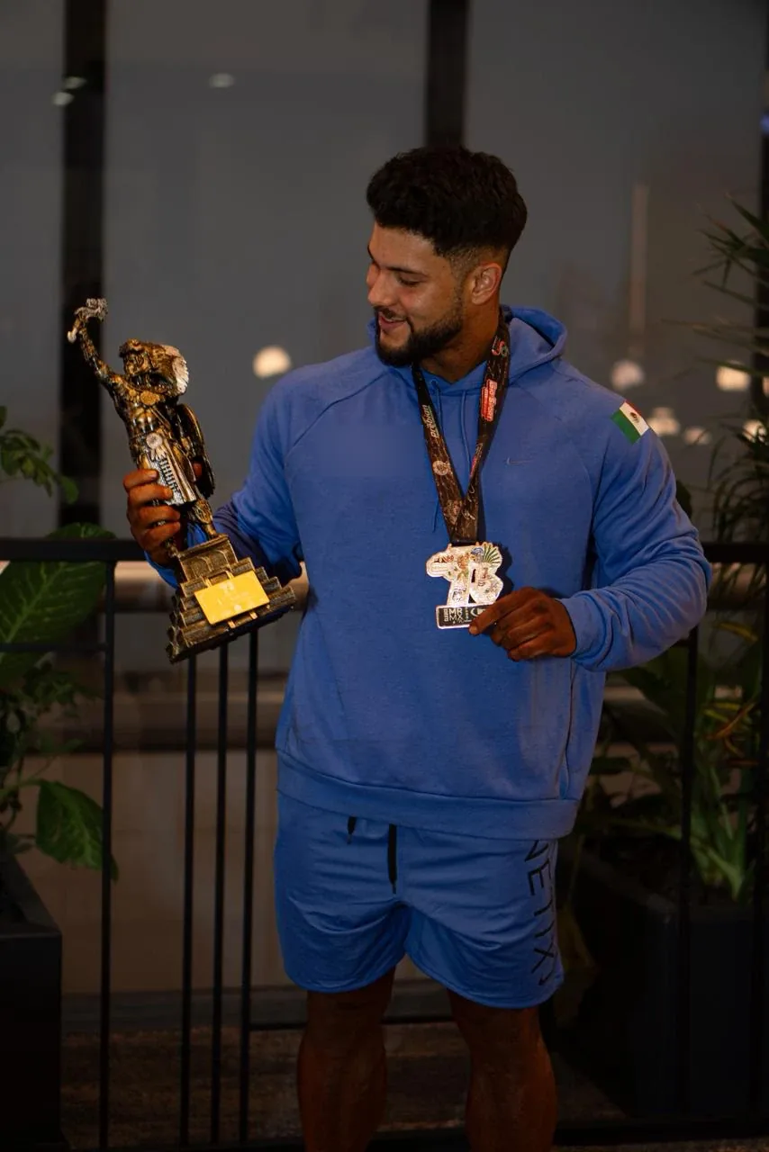 Kinetix athlete in a blue hoodie with his trophy and medal
