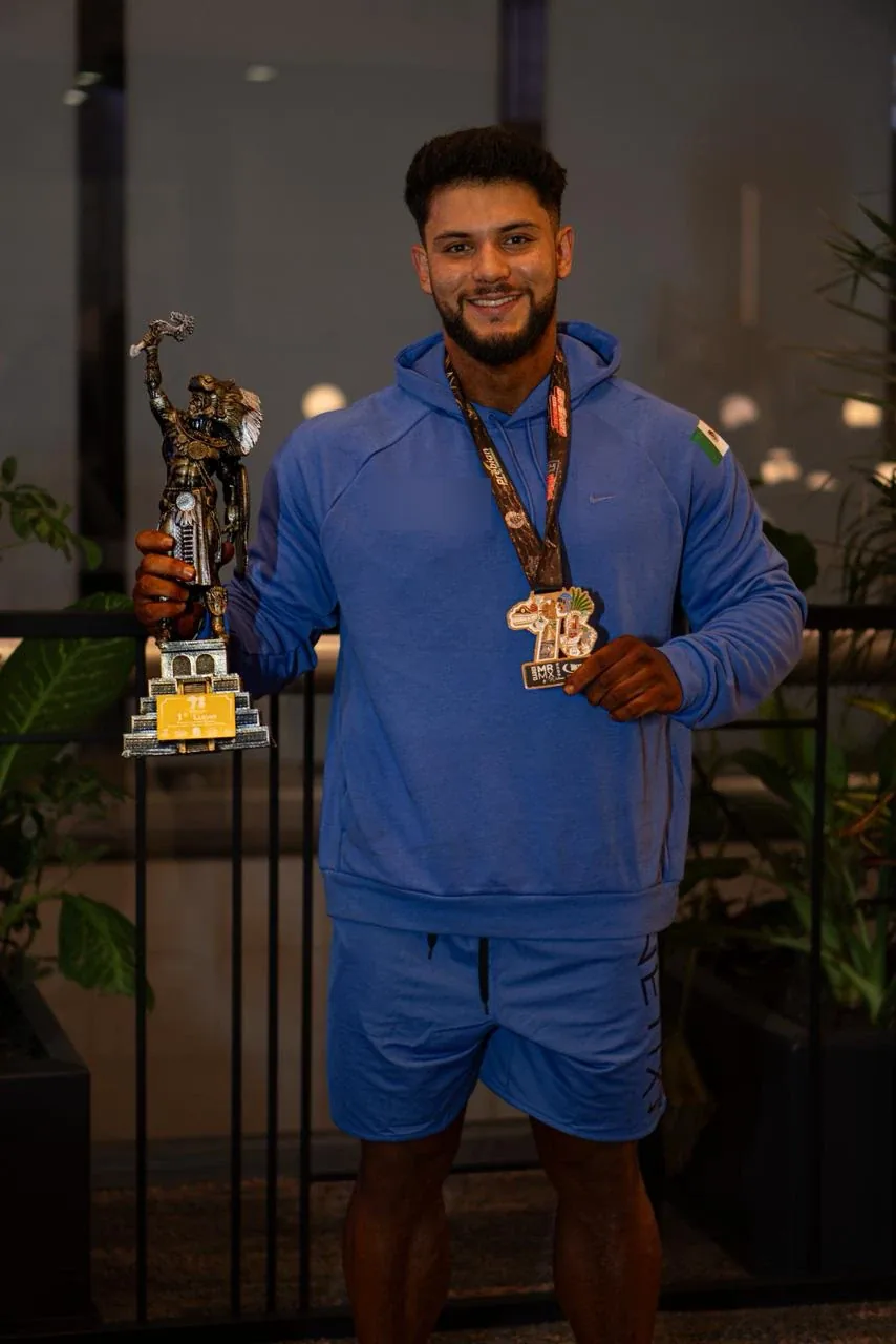 Kinetix athlete in a blue hoodie with his trophy and medal