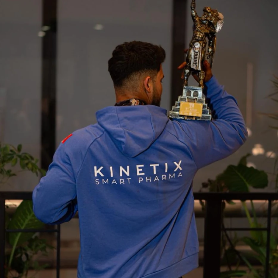 Kinetix athlete in the Kinetix Smart Pharma uniform holding his trophy